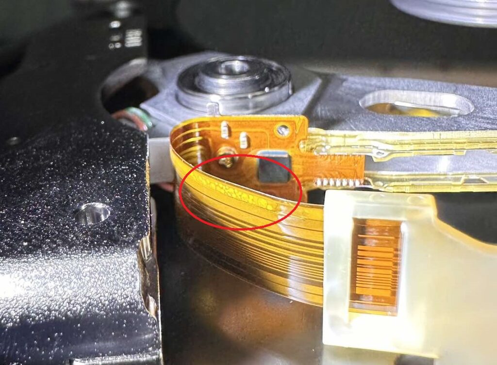 Uszkodzona taśma sygnałowa głowic wewnątrz dysku Toshiba DT01ACA100 po przepięciu elektrycznym