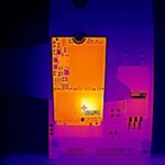 Obraz przedstawia zdjęcie termiczne płyty elektronicznej podczas diagnostyki. Widoczna jest r&oacute;żnorodność temperatur, z najjaśniejszym punktem osiągającym 67,8&deg;C. Monitorowanie termiczne pozwala na identyfikację potencjalnych problem&oacute;w związanych z przegrzewaniem się komponent&oacute;w, co jest kluczowe w procesie analizy i zapobiegania awariom sprzętu elektronicznego.